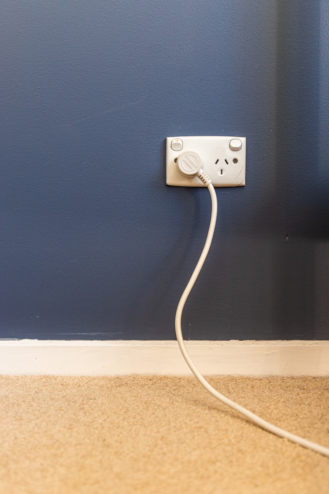 white-electric-plug-on-blue-wall