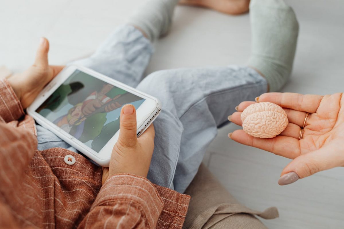 a-kid-holding-a-cell-phone-near-a-person-s-hand