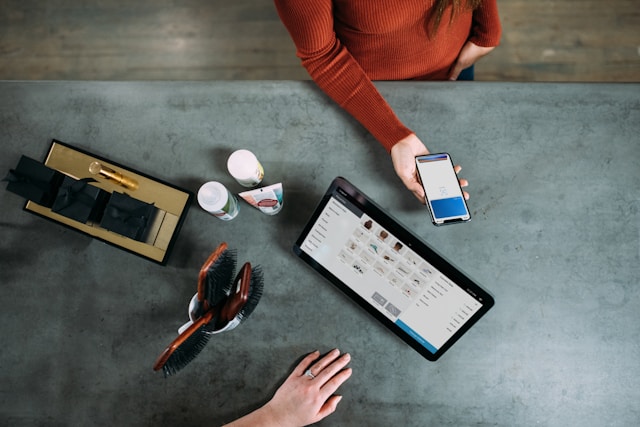 person-holding-smartphone-beside-tablet-computer
